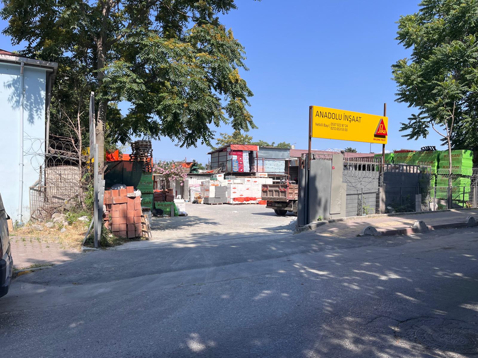 Anadolu İnşaat malzeme sahası girişi ve sarı Sika bayi tabelası